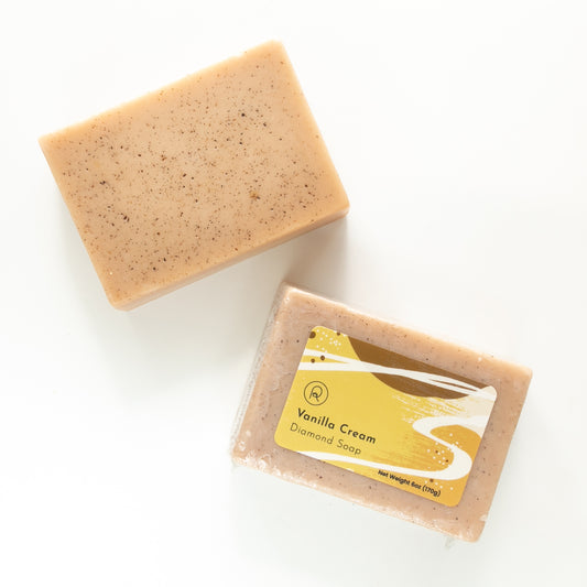 Bar of vanilla cream soap with packaging on a white background